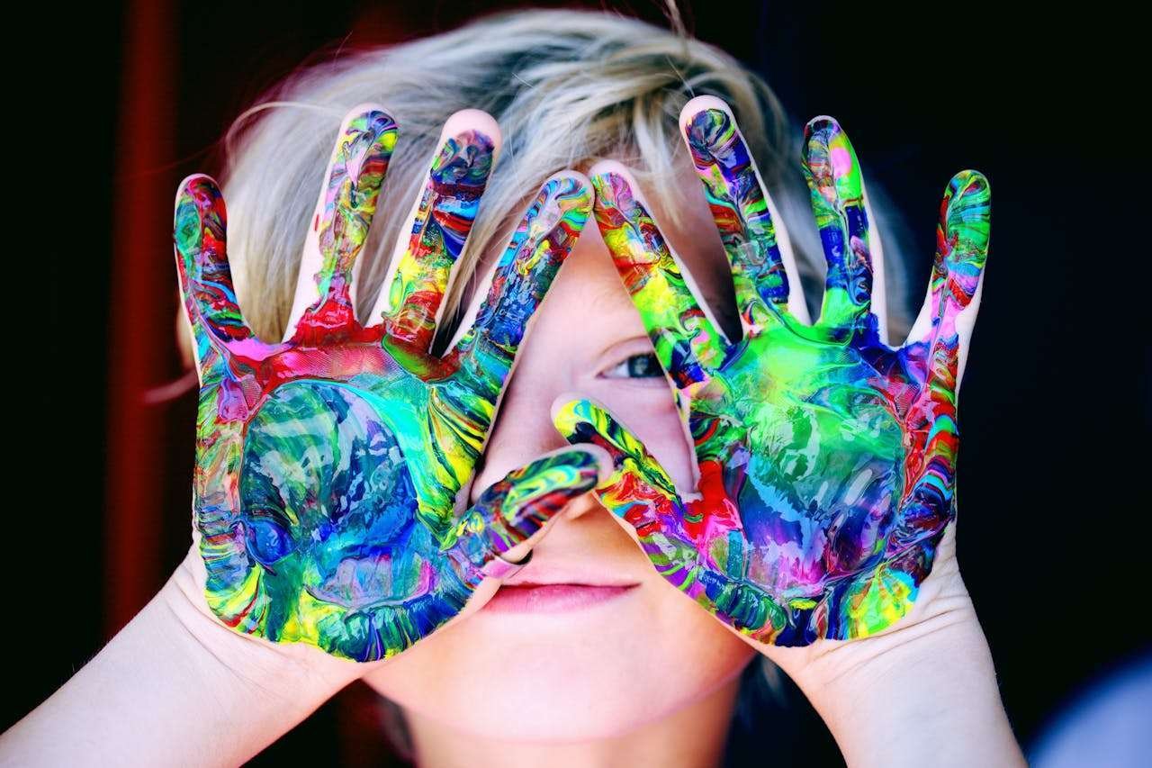 How Diamond Painting Sets for Beginners Ensure Easy Use Without Sacrificing Quality A KId With Multicolored Hand Paint
