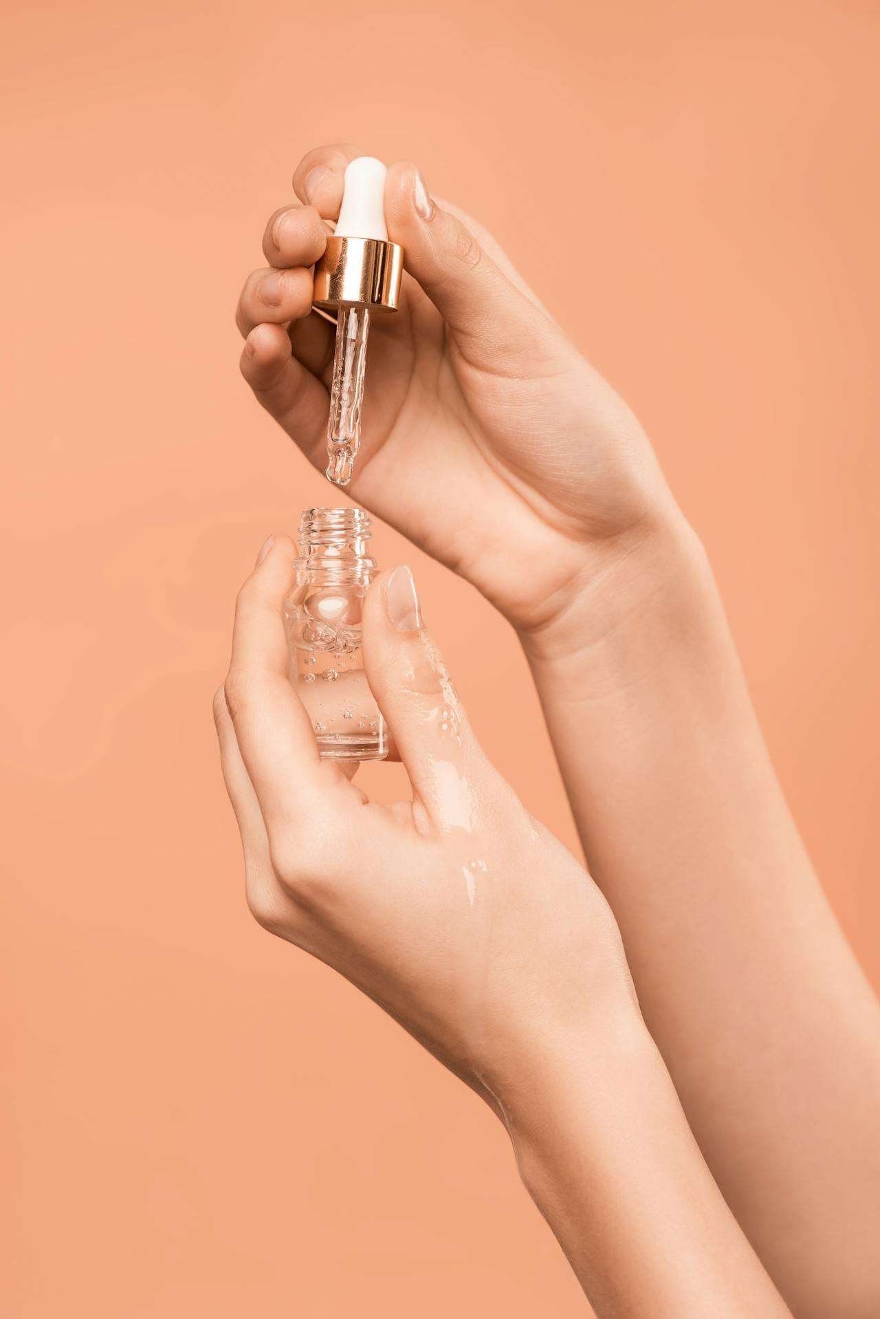 a person holding a dropper and a bottle of liquid serum